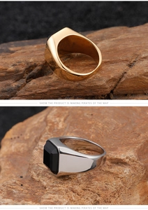 Macro detail of men's square signet rings with black gemstones on volcanic rock