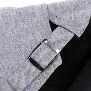 Detail of adjustable cotton strap with dark metal buckle on a solid grey beret hat