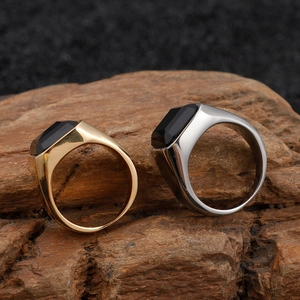 Men's vintage stainless steel rings with black rectangular stones on a wooden base