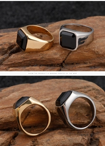 Macro detail of men's gold and silver signet rings with square black onyx stones