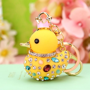 Detail of cute yellow duck keychain with colorful rhinestones and pink crown accent