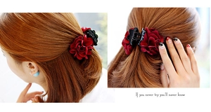Detail view of a medium hair claw clip featuring elegant red and black fabric roses