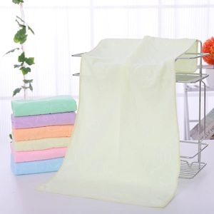 Detail showing various pastel microfiber towels with embossed patterns on metal rack