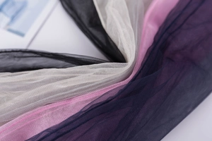 Close-up of sheer mesh socks in black, beige, pink and blue showing delicate fabric texture