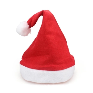 Detailed view of the soft red plush fabric and white pompom on this classic Christmas hat