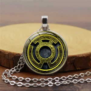 Close-up of a silver necklace featuring a yellow Green Lantern logo on a wood slice
