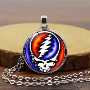 Macro detail of silver Grateful Dead skull necklace on a rustic wooden base display