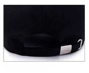 Detail of adjustable metal buckle and cotton fabric texture on the black baseball cap