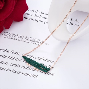 Collier élégant en or rose avec pendentif crocodile en strass vert sur pages de livre