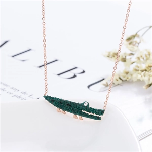 Détail du collier en or rose avec un pendentif crocodile orné de strass verts brillants