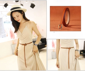 Detail of brown slim leather belt with vintage oval buckle and knot style on dress