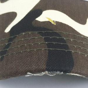 Détail macro du bord d'une casquette camouflage avec quadruple couture de renfort