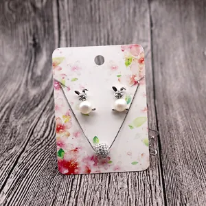 Detail of silver bunny jewelry set with pearls and crystals on floral display card