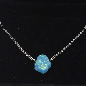 Delicate silver chain necklace featuring a blue synthetic opal Hamsa hand pendant