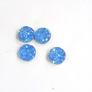 Macro view of four 8mm blue round resin rhinestones with sparkling mineral texture