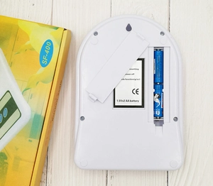 Detailed back view of SF-400 kitchen scale showing AA battery compartment and packaging
