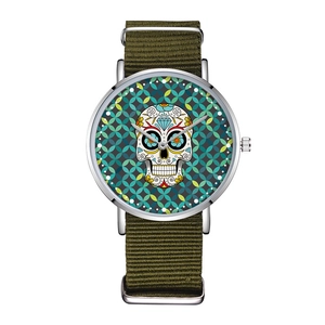 Close-up of olive nylon strap watch featuring a colorful sugar skull design dial