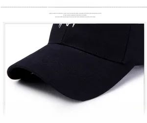 Gros plan sur la visière de la casquette noire montrant le sergé et les coutures parallèles