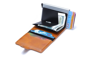 Detail of orange lychee leather wallet with silver automatic pop-up aluminum card holder