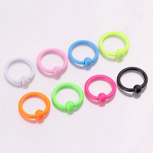 Detailed view of eight neon-colored stainless steel CBR piercing rings for nose and ears