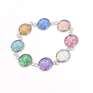 Kleurrijke glitterende hars kralen armband met zilveren schakels op wit decor