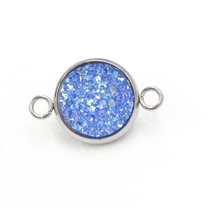 Detail van ronde blauwe glitterbedel met dubbele roestvrijstalen verbindingsringen