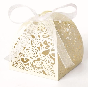 Elegant beige laser-cut floral candy box with ribbon bow on white background