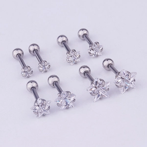 Detailed view of eight stainless steel star-shaped cartilage studs with clear cubic zirconia