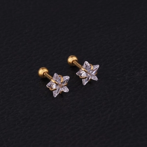 Macro shot of gold star-shaped zircon ear studs with screw backs on black leather