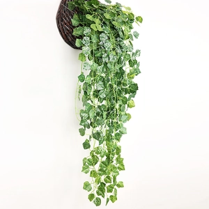Hanging artificial ivy plant with lush green leaves in a woven basket on white background