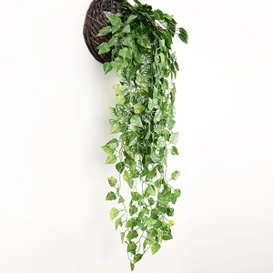 Artificial green hanging plant in woven basket for wall decoration and home interior