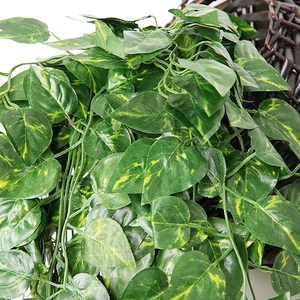 Close-up of artificial ivy leaves with yellow veins in a brown hanging basket