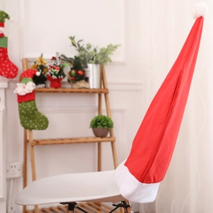 Festive red Christmas hat chair cover on a white chair in a cozy holiday home setting