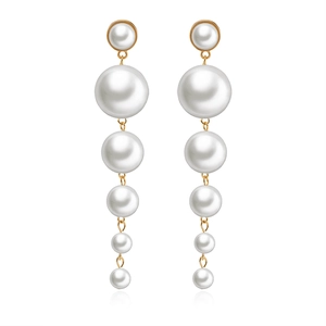 Elegant white pearl drop earrings with gold metal links in a vertical symmetric style