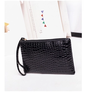 Detail of black crocodile embossed wristlet pouch with shiny finish and gold zipper