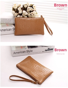Detailed view of the brown crocodile pattern texture and wrist strap on this flat PU clutch