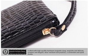Detailed macro view of the gold zipper and crocodile pattern leather wristlet strap