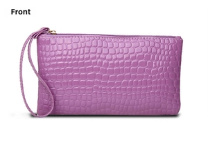 Detail of purple crocodile-pattern wristlet clutch with shiny texture and top zipper