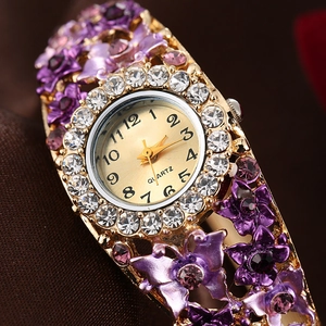 Elegant gold quartz bangle watch featuring purple enamel flowers and crystal accents