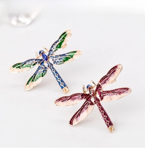 Detailed macro view of colorful enamel dragonfly brooches with sparkling crystal heads