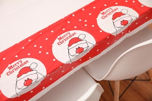 Detail of red Christmas PVC tablecloth with Santa Claus motifs and Merry Christmas text
