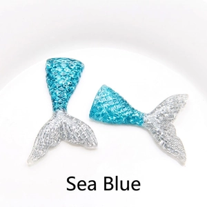 Detail of sea blue resin mermaid tail pendants with shimmering glitter for DIY crafts