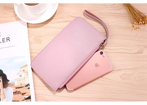 Close-up of pink faux leather wallet beside an iPhone showing large capacity and lychee texture