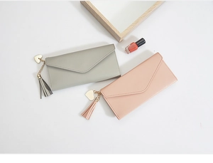 Detailed close-up of long envelope wallets with heart pendant and tassel decoration