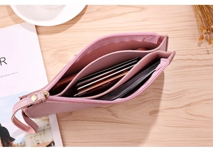 Detail view of pink leather long wallet showing multi-layer accordion card slots and compartments