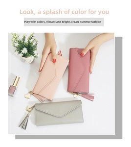 Detail of long envelope wallet with heart pendant and tassel in pink, rose, and grey