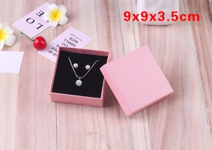Pink jewelry gift box 9x9x3.5cm with black foam insert on wooden floor background