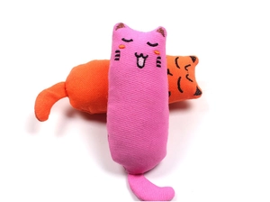 Macro detail of textured cotton catnip toys in pink and orange with cute cat face embroidery