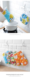 Close-up of heat-resistant oven mitts and pot holders with sunflower patterns and hanging loops