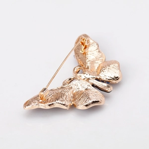 Back view of butterfly brooch in golden enamel alloy with detailed wing texture